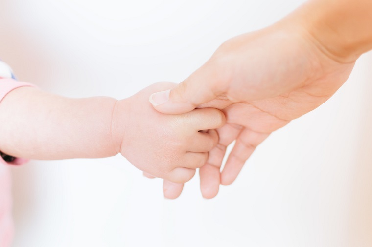 大人の手を握る赤ちゃんの手